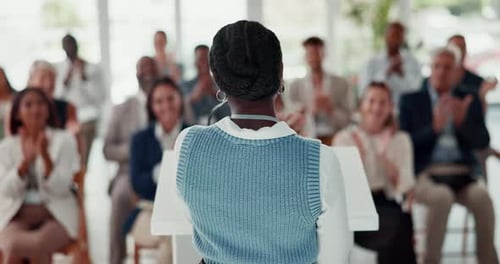 Professional Speaker Addressing Cheering Audience at Conference