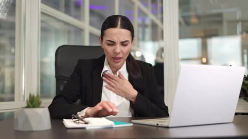 Female Office Worker Typing on Laptop Keyboard and Coughing at Workplace