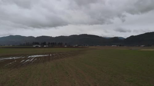 Terres agricoles : champs de cultures, rangées de légumes à la ferme, dans une vallée de campagne entourée de montagnes sur le terrain