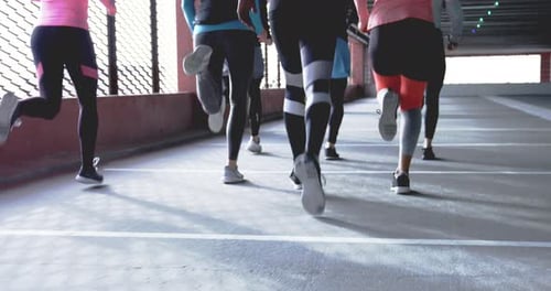 Gruppe von Läufern von hinten gesehen, gemeinsam in urbaner Umgebung joggen Aktiv