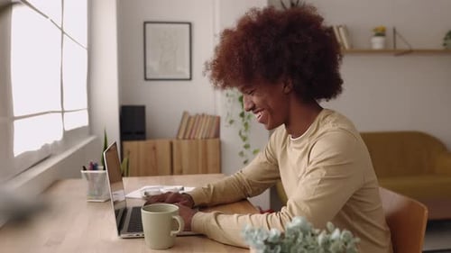 Side View of Young African American Student Man Working on Laptop at Home Studio