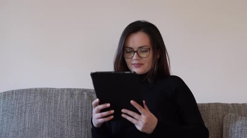 Woman Using Tablet on Couch at Home
