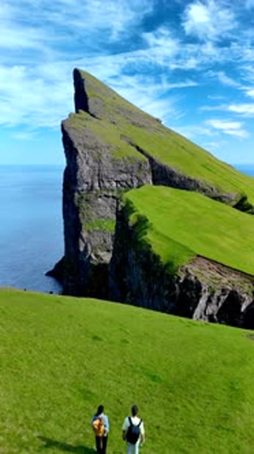 Breathtaking Exploration of Rugged Cliffs in the Faroe Islands on a Sunny Day
