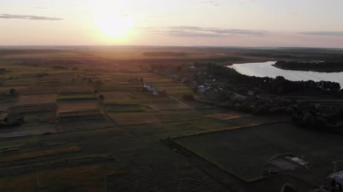 Luftaufnahme von Ackerland neben einem Fluss in der Ukraine während eines wunderschönen Sonnenuntergangs