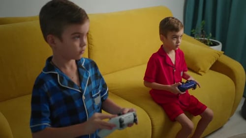 Niños jugando a videojuegos en un sofá durante una tarde relajada juntos