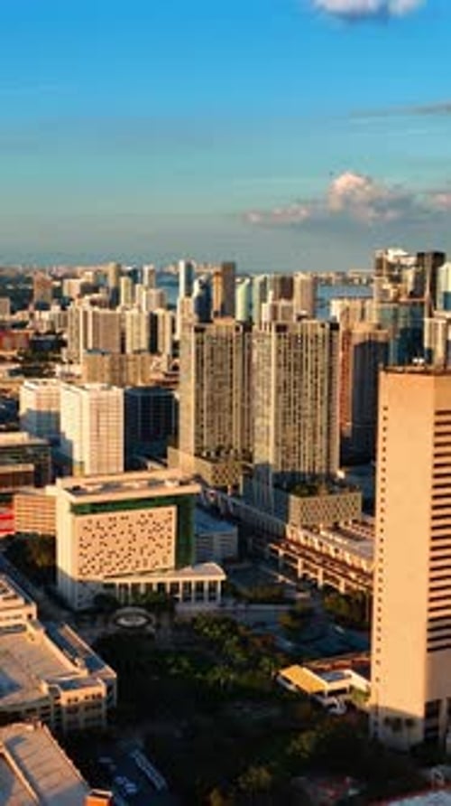 Setting sun lighting the cityscape of a beautiful modern city. Aerial view of Miami, Florida, USA.