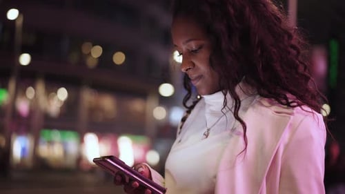 Woman Using Smartphone at Night in City
