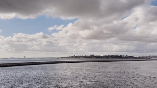 Ferries, boats, sailboats, birds, breakwater, pier, waves in the sea in cloudy weather in autumn