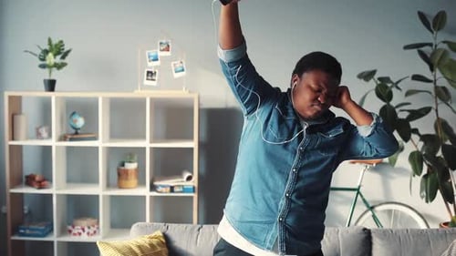 Enthusiastic young man listening to music and dancing