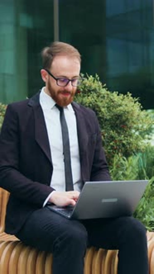 Smiling Bearded Businessman Working on Bench with Laptop Outdoors Man Freelancer in Glasses Learn