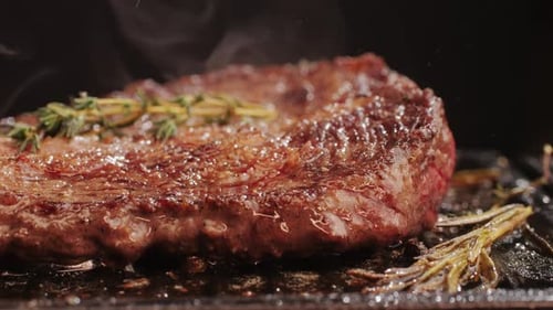 Fresh Marbled Beef with Pepper Salt and Rosemary Closeup Macro Cooking Juicy Steak on Grill with Oil