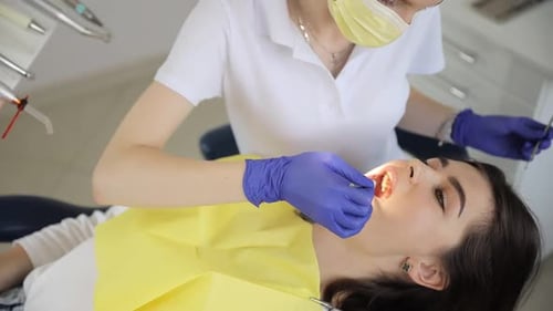 Dentist Examining Young Woman's Teeth