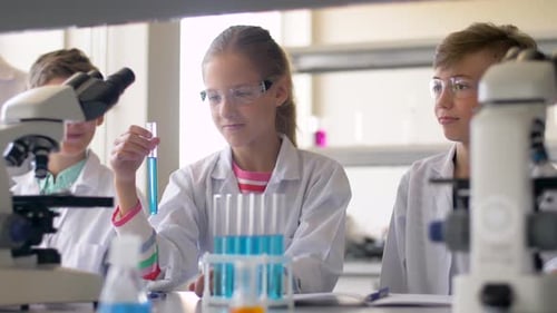 Children in Lab Coats Conducting Science Experiment