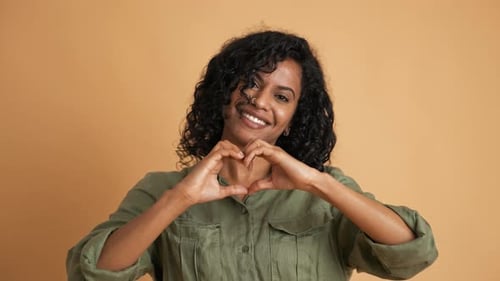 Smiling Woman Makes Heart Shape With Hands