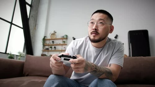 Excited Man Playing Video Game at Home