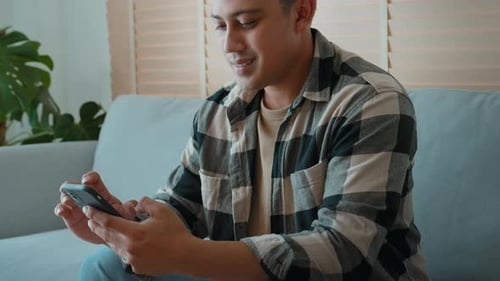 Man Using Smartphone on Sofa, Close Up