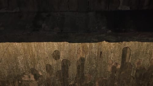 Cinematic aerial drone footage gliding through an abandoned factory interior. Slow and atmospheric