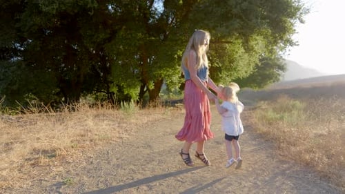 Woman and Child Spinning on Rural Dirt Path