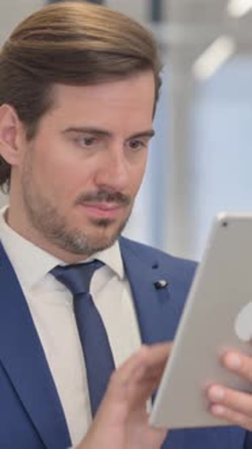 Serious Man Using Tablet in an Office Setting