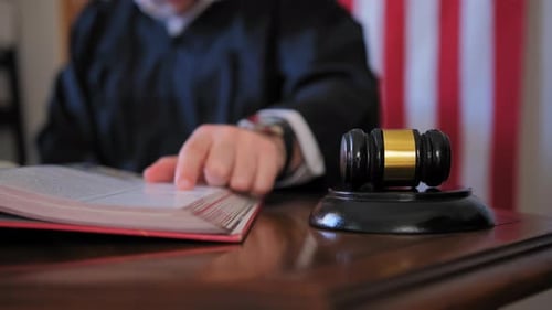 Gavel in Courtroom with Judge Reading Book