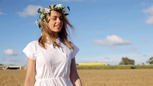 Woman with flower crown walks in wheat field