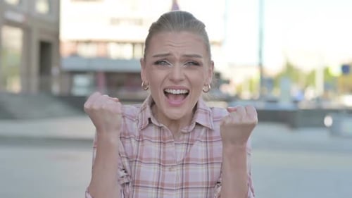 Enthusiastic Woman Celebrating Success in Urban Setting