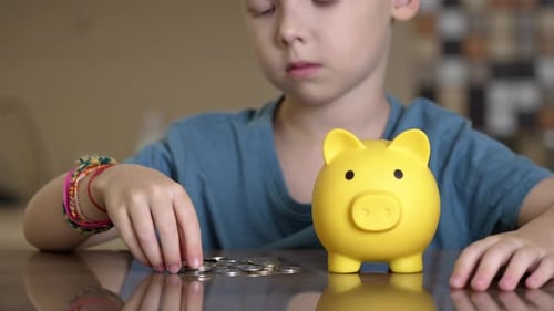 Child Saving Money and Investing in Piggy Bank
