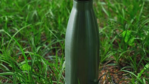 Water Bottle Reusable Steel Thermo Water Bottle on Green Grass Sustainable Lifestyle Plastic Free