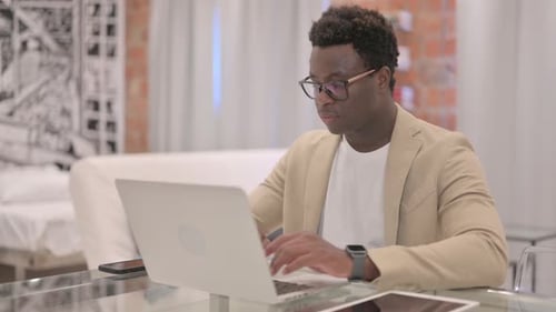 Man Works at Laptop in Modern Office Setting