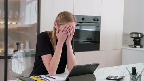 Woman Crying While Using Tablet in Kitchen