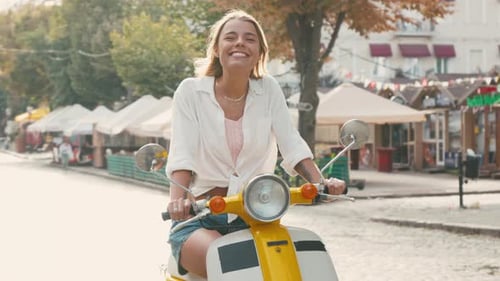 Une femme prend des poses confiantes alors qu'elle est assise sur une moto