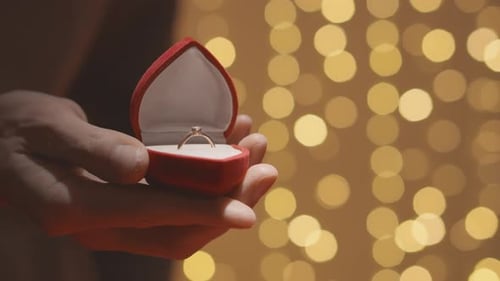 Closeup of Hands Opening a Red Box for Wedding Ring and Jewelry