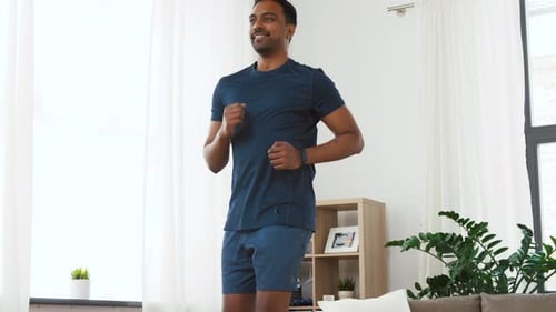 Konzept für Sport, Fitness und gesunden Lebensstil - Indischer Mann läuft vor Ort
