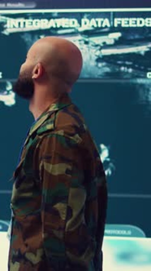 Man Watches Monitors in Futuristic Control Center