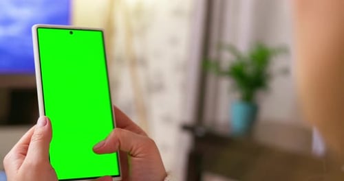 Back View of Brunette Holding Smartphone with Green Screen Watching Content