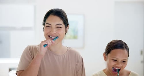 Woman and Child Brushing Teeth in Bathroom