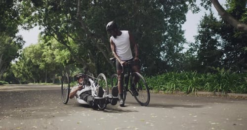 Two handsome men cycling through the woods together