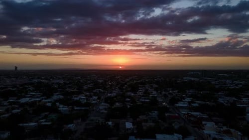 Hyperlapse aerial view of a beautiful after dusk sunrise over the city, fly towards, time lapse