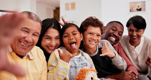 Parents, grandparents and children for funny selfie together on the sofa in living room