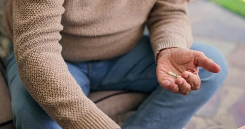 Senior Man Taking Medication with Glass of Water