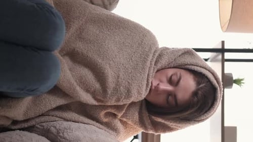 Woman Rests with Cold Wrapped in Blanket Indoors