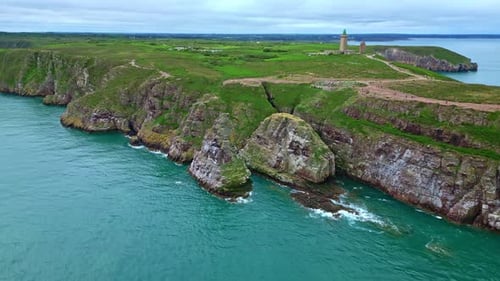 Panorama-Drohnenbewegung entlang der Halbinsel Cap Fréhel mit dramatisch Klippen und Leuchtturm entlang des Vi.
