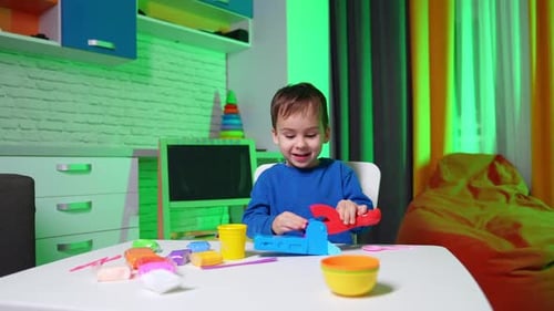 Excited Child Plays with Playdough at Table