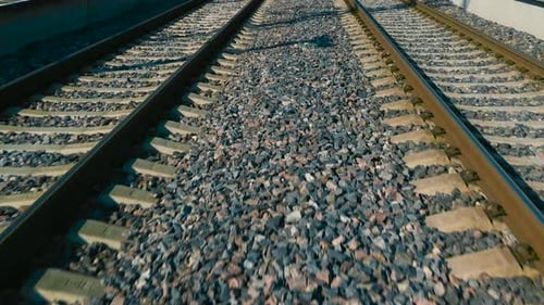 Luftüberführung zwischen Bahngleisen, entlang einer Eisenbahnstahllinie. Zugstrecke an einem sonnigen Tag
