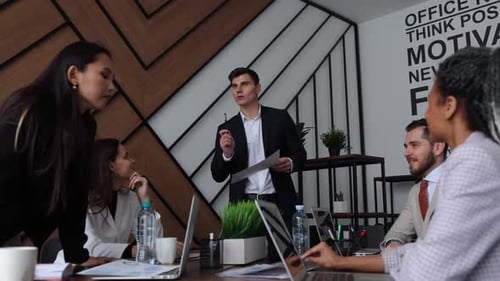 Colleagues at a Large Table in the Office Discuss Business Development Plans