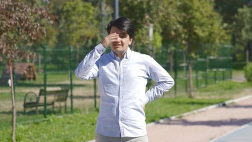 Le jeune homme suffoque à cause du soleil et de la chaleur à l'extérieur.