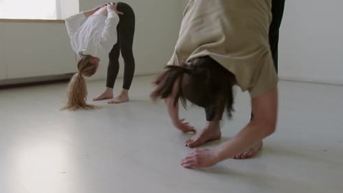 Young Adults Stretching in Bright Studio