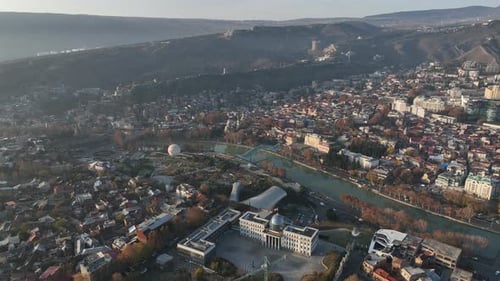 Aerial panoramic view of Tbilisi, Georgia, with the Kura River, city center, and Mount Mtatsminda
