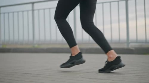 Woman Running on Sidewalk for Health and Fitness