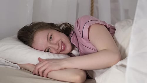 This Closeup Showcases a Tranquil Moment of a Woman Enjoying a Peaceful Break in Her Cozy Bedroom